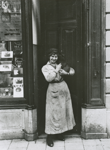 874828 Portret van het dienstmeisje Dien van den Oudenalder voor de ingang van de bovenwoning van de Koninklijke ...